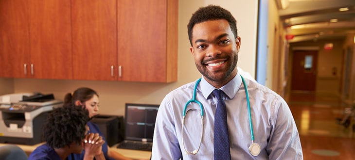 Male Doctor At Nurse's Station In Hospital