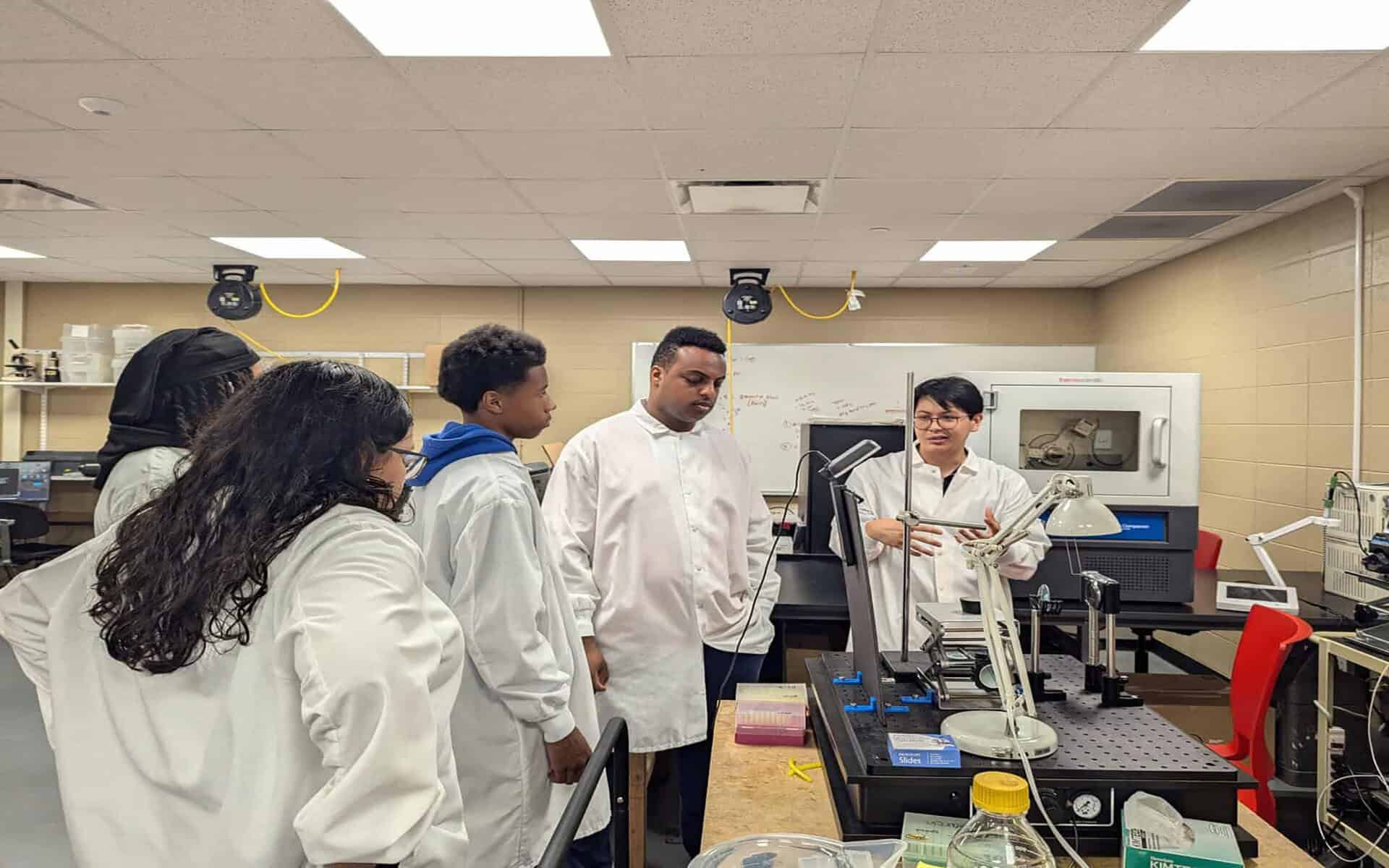 Innovative students in lab coats participate in STEM education at CPASS Foundation.